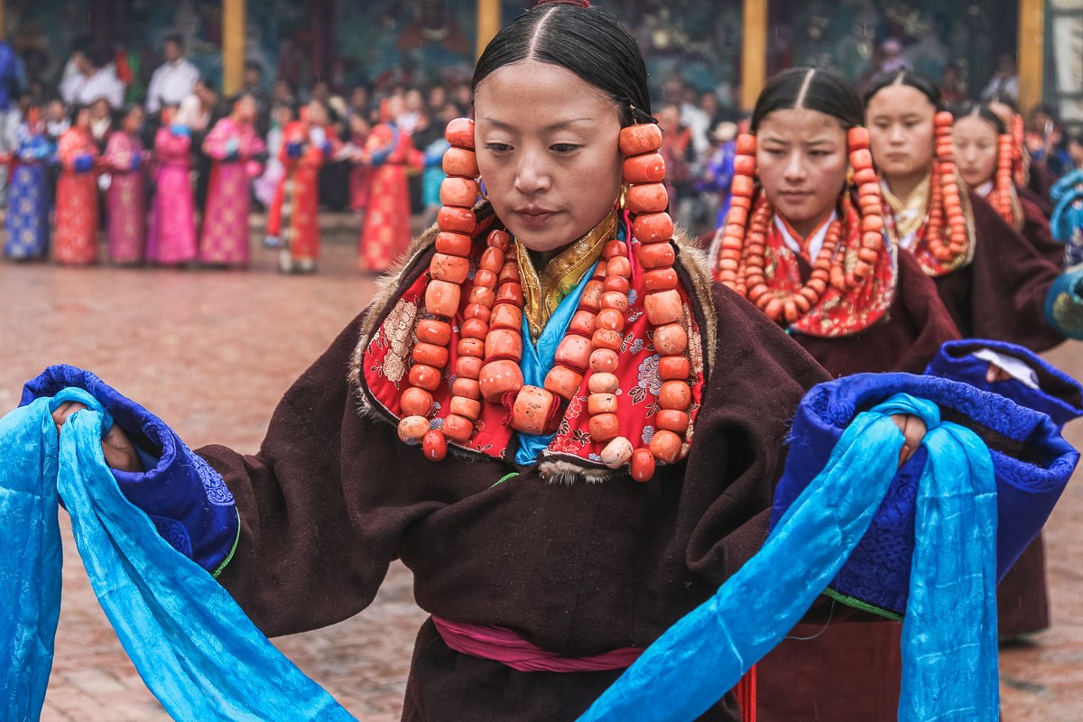 Vrouwen met bloedkoralen ketting dansen tijdens festival in Repkong