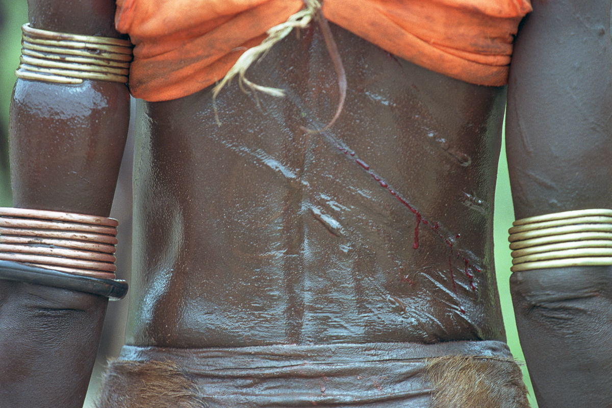 Het bloed stroomt over de rug van deze Hamar vrouw tijdens het Bulljump ritueel.